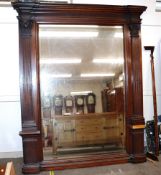 A large Victorian oak hall mirror, with inverted pediment top above bevelled plate, flanked by