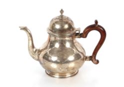 An Elizabeth II silver teapot, of baluster form, the dome lid surmounted by a turned finial,
