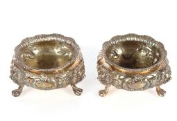 A pair of Victorian silver salts, of circular form with raised foliate embossed decoration on