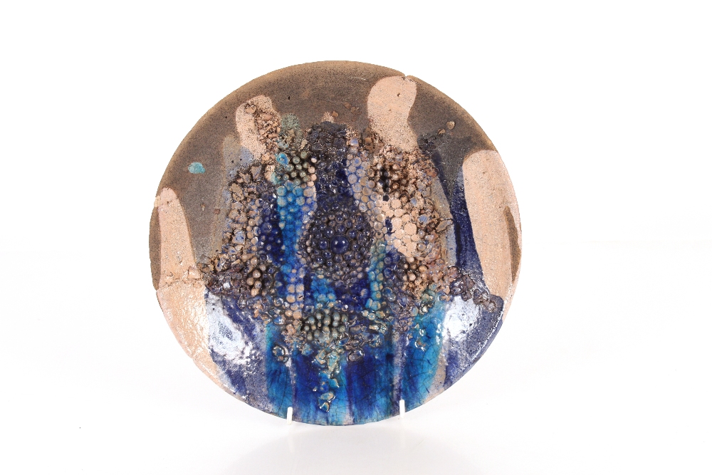 A brown and blue glazed pottery plate, with raised decoration possibly Harriet Colridge, 29cm