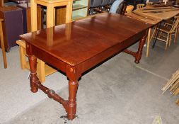 A teak ships table, the three section top raised on bold baluster supports united by stretchers,