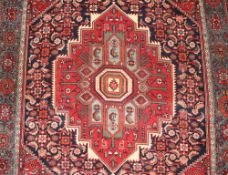 A Persian wool rug, having central lozenge design on a stylised floral ground within multi