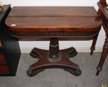 A 19th Century rosewood card table, the fold over swivel top raised on a turned fluted leaf carved