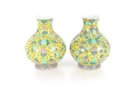 A pair of Oriental baluster vases, decorated flowers on a yellow ground, 32cm high