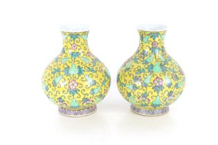 A pair of Oriental baluster vases, decorated flowers on a yellow ground, 32cm high