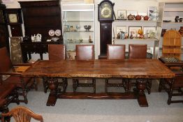A large oak refectory table, the thick plank top raised on bold baluster cup and cover supports