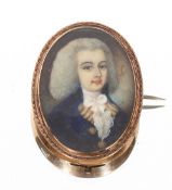 An 18th Century miniature of a young gentleman wearing a powdered wig set in an oval yellow metal