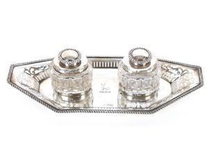 A late Victorian silver inkstand of elongated octagonal shape with pierced gadrooned border, cut