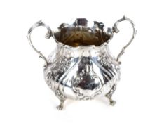 A Victorian silver sucrier, with raised embossed foliate panels flanked by scroll handles on four