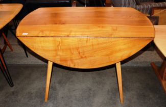 An Ercol drop leaf dining table, raised on tapering square section supports having rounded drop