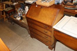 A reproduction mahogany bureau fitted four graduat