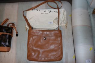 A Bailey & Quinn tan cross body bag and outer prot