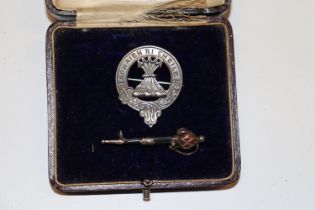 A Scottish silver Cameron Clan brooch; and a white