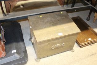 A brass coal box raised on paw feet