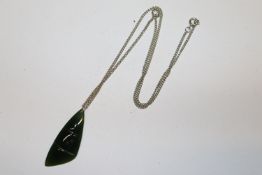 A jade coloured pendant hung to fine link chain
