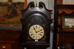 A carved oak longcase clock with painted dial