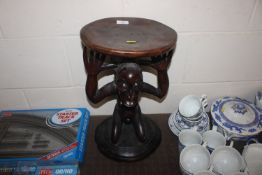 A carved hardwood figural African stool
