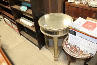 A mirrored circular topped side table
