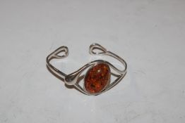 A large Sterling silver and amber torque bangle, a