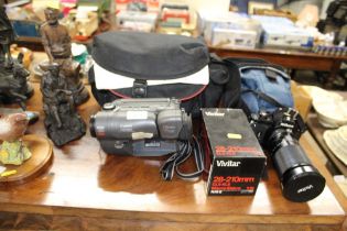 A Canon camcorder with carry bag, and a Nikon EM c