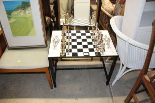 A tile topped games table with a set of chess piec