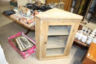 A stripped pine glazed corner cabinet