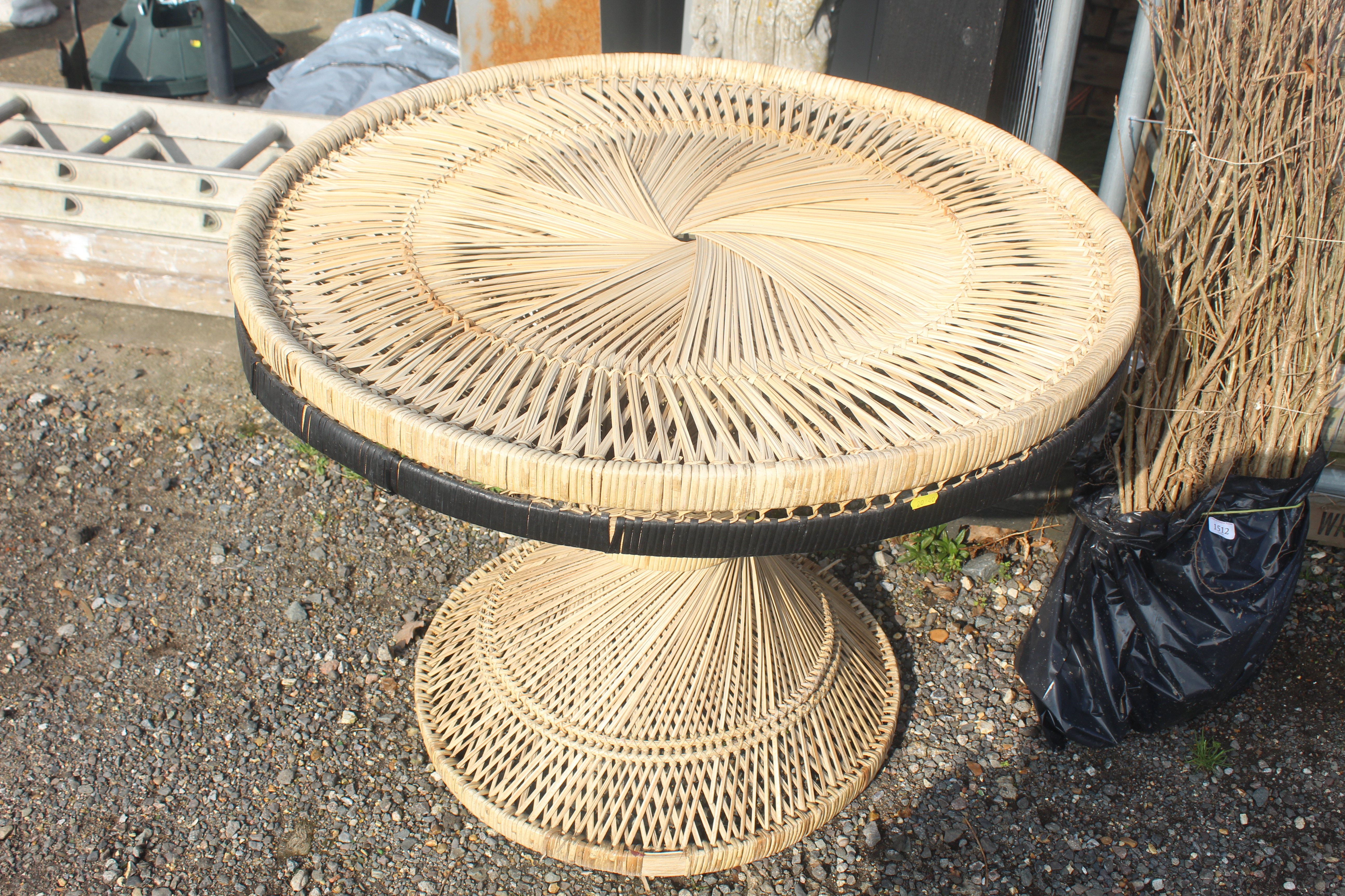 A rattan style circular table on spiral twist base