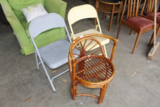 A small wicker tub shaped chair and two metal fram