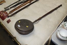 An antique copper warming pan with pierced lid and
