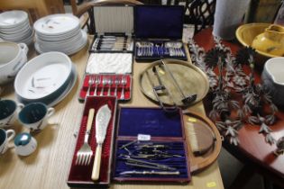 A pair of plated asparagus servers, a plated ladle