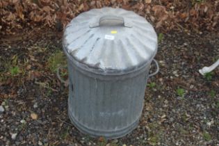 A small galvanised dustbin with lid