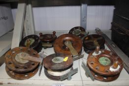 Eight wooden and brass vintage fishing reels