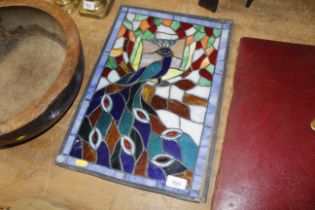 A stained glass panel decorated with a peacock