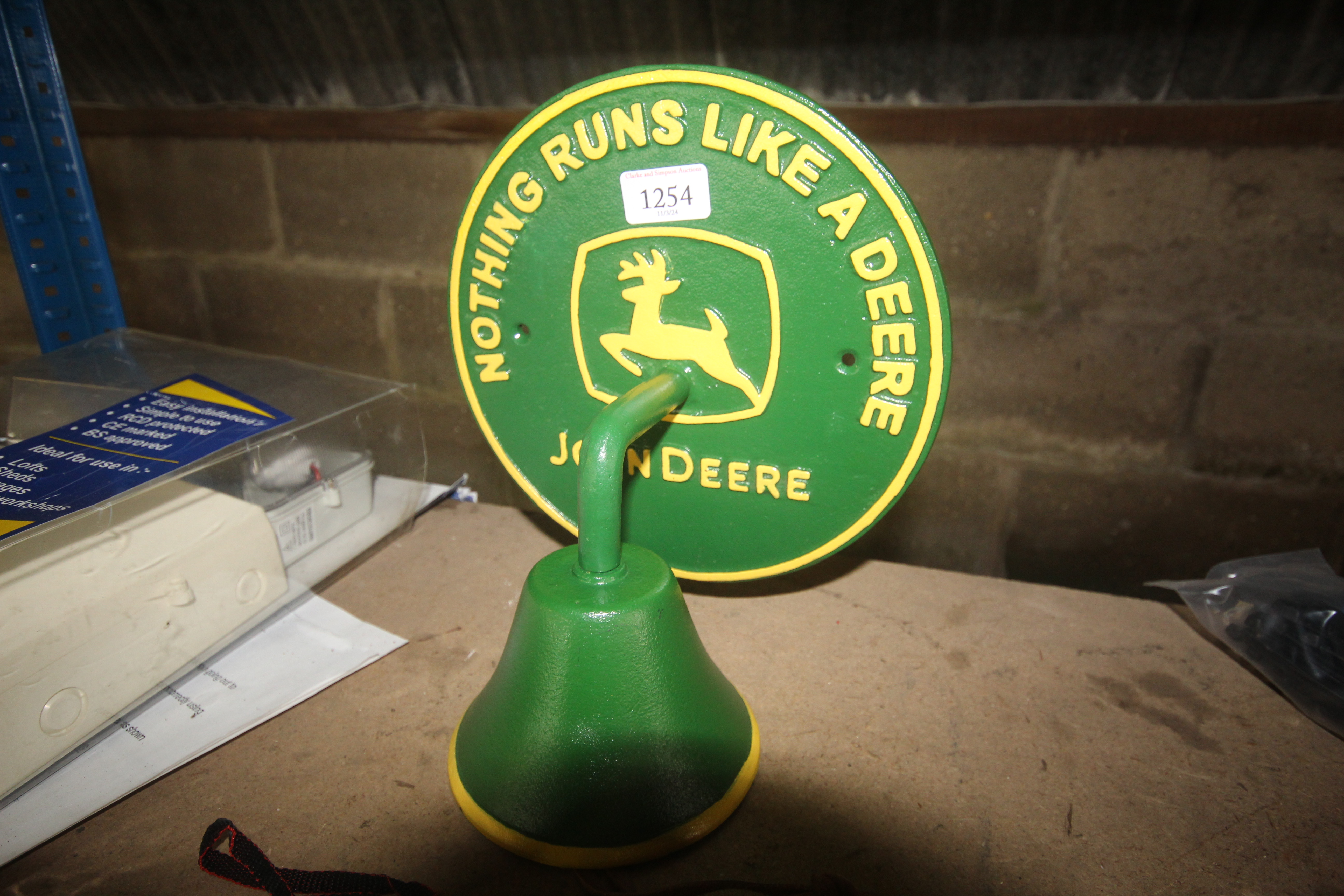 A painted cast iron wall plaque for John Deere wit
