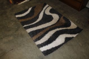 A black, white and brown patterned wool rug approx