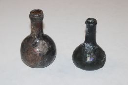 Two antique small glass bottles,10.5cm and 12.5cm respectively