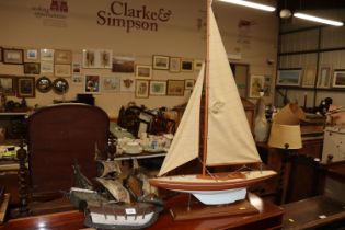 A wooden model of a galleon and a model of a yacht