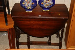 An oak gate leg dining table with barley twist sup