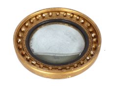An antique gilt wood convex wall mirror