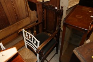 A 1920's oak elbow chair with barley twist columns