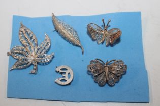 A collection of silver brooches