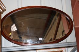 An early 20th Century mahogany framed oval bevel e