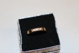 A yellow metal ring set with white stones