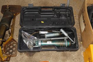 A plastic case containing grease guns and attachme