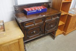 An oak sideboard, fitted two drawers raised on barley twist supports