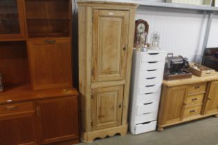 A stripped pine upright corner cupboard