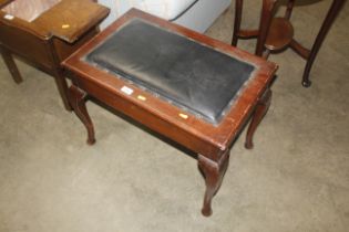 A mahogany piano stool raised on cabriole supports