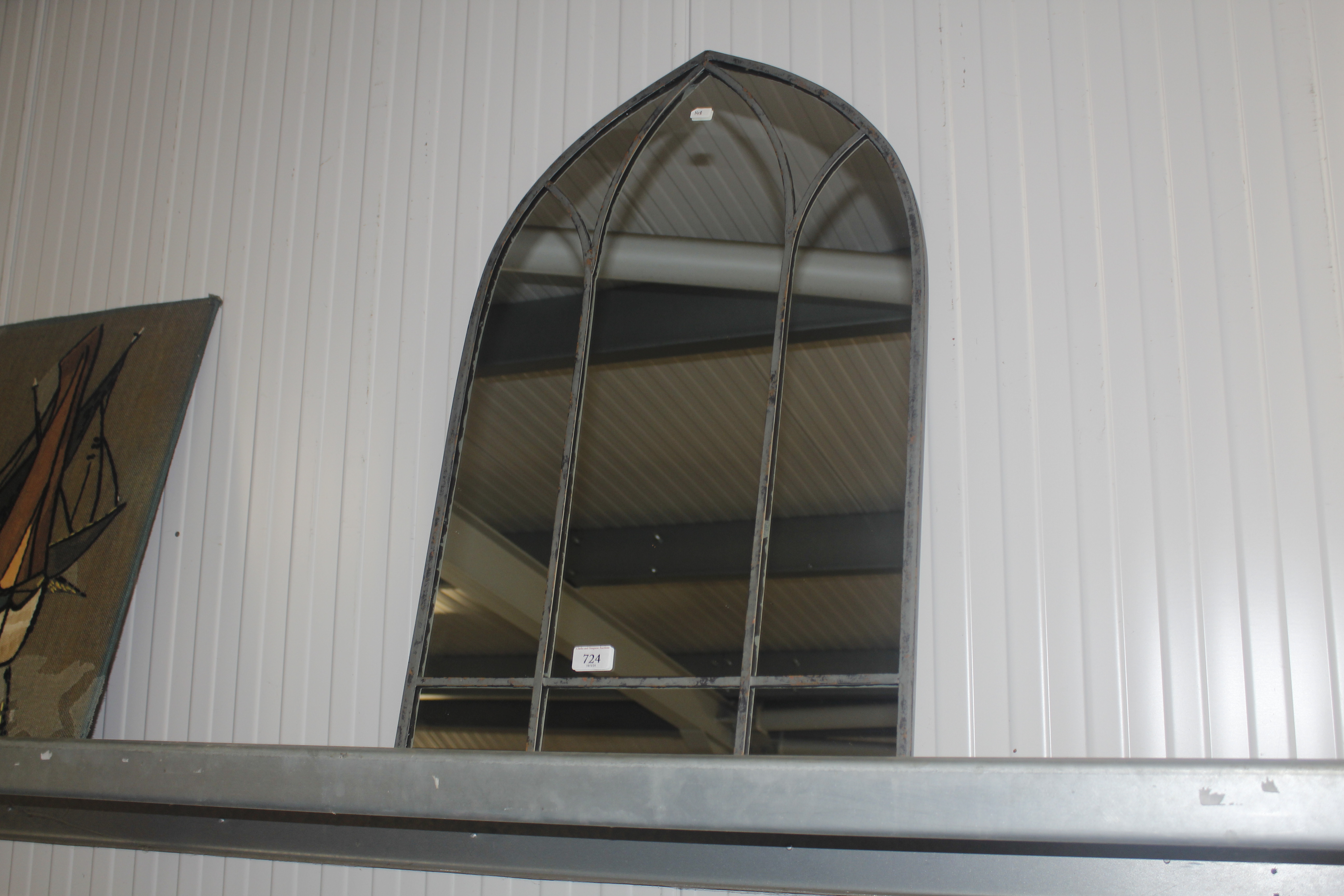 An arched framed wall mirror (148)