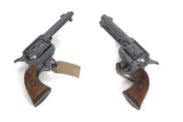 A pair of decorative Colt 45 revolvers (metal and