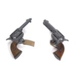 A pair of decorative Colt 45 revolvers (metal and